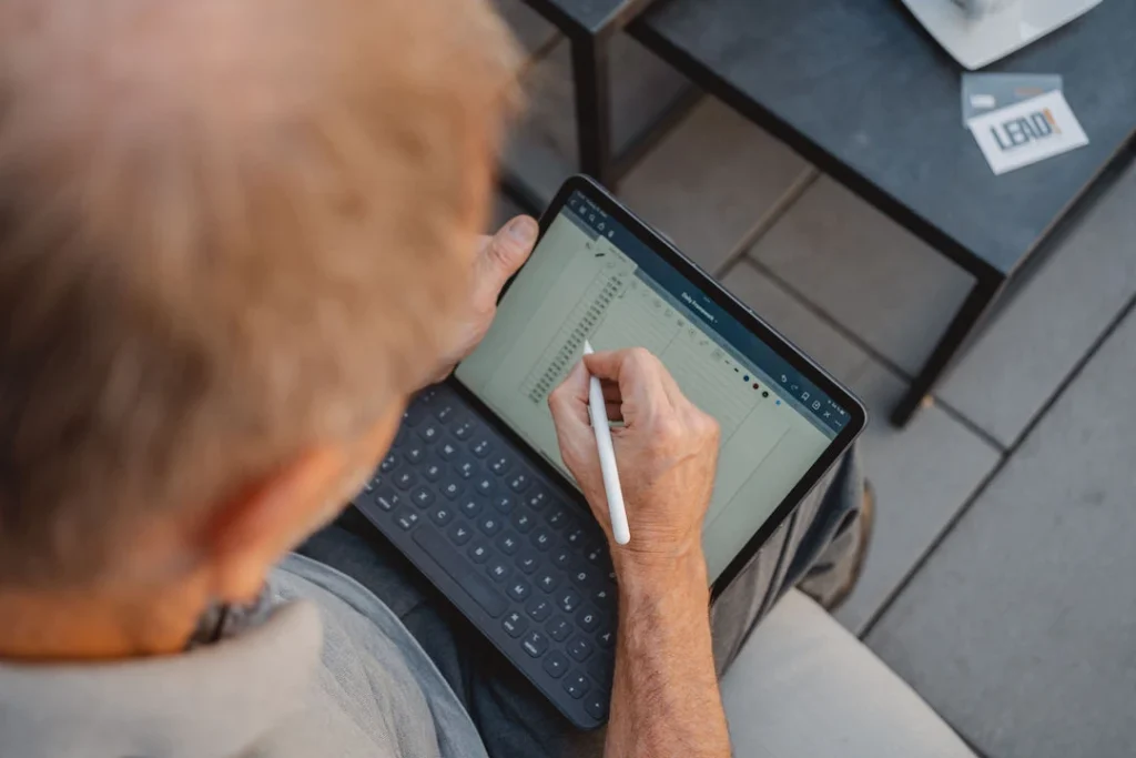 Thomas Brüser schreibt mit seinem Apple Pencil etwas in eine Excel-Tabelle auf seinem Tablet